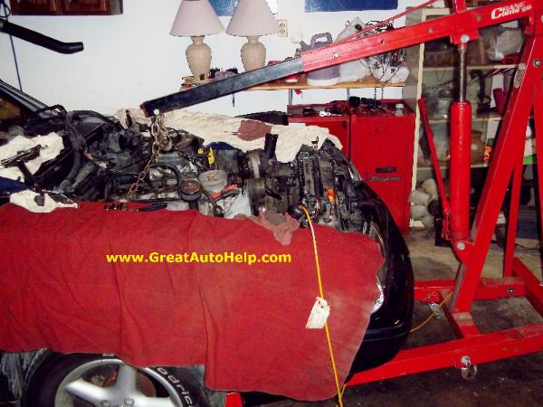 Removing Ford Mustang engine with crane or cherry picker.